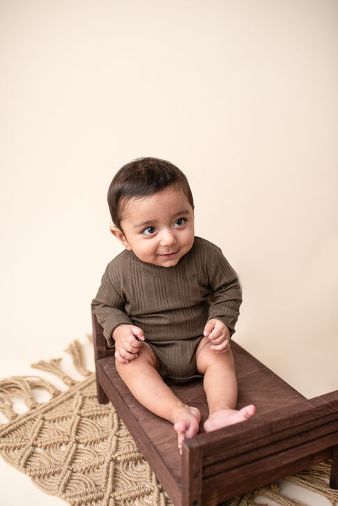 Sitter session Essex image showing a baby surrounded by soft textures and natural light