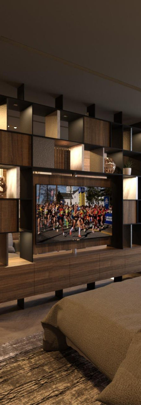 Mueble para pantalla más librero hecho de madera. Los colores del mueble son cafés y negro. Tiene varias compartimientos cuadrangulares. El mueble está al centro de una recámara, entonces también se observan parcialmente una cama, un sillón y un cuadro decorativo. Toda la habitación está decorada con tonos tierra neutros.