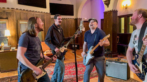 the band singing into a microphone at Echo Mountain Recording Studio
