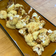 roasted cauliflower on a mustard yellow rectangular serving dish