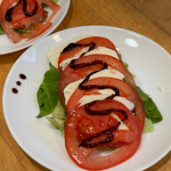 caprese salad with a balsamic drizzle on a white plate