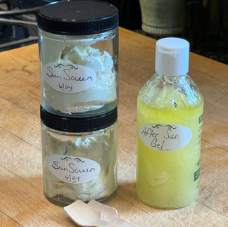 2 stacked jars containing homemade sunscreen and a squeeze bottle with after-sun gel