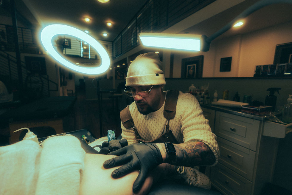 Eye-level view of tattoo artist working on a black and grey portrait tattoo