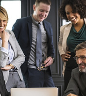 Group of business people smiling and looking at a computer screen.