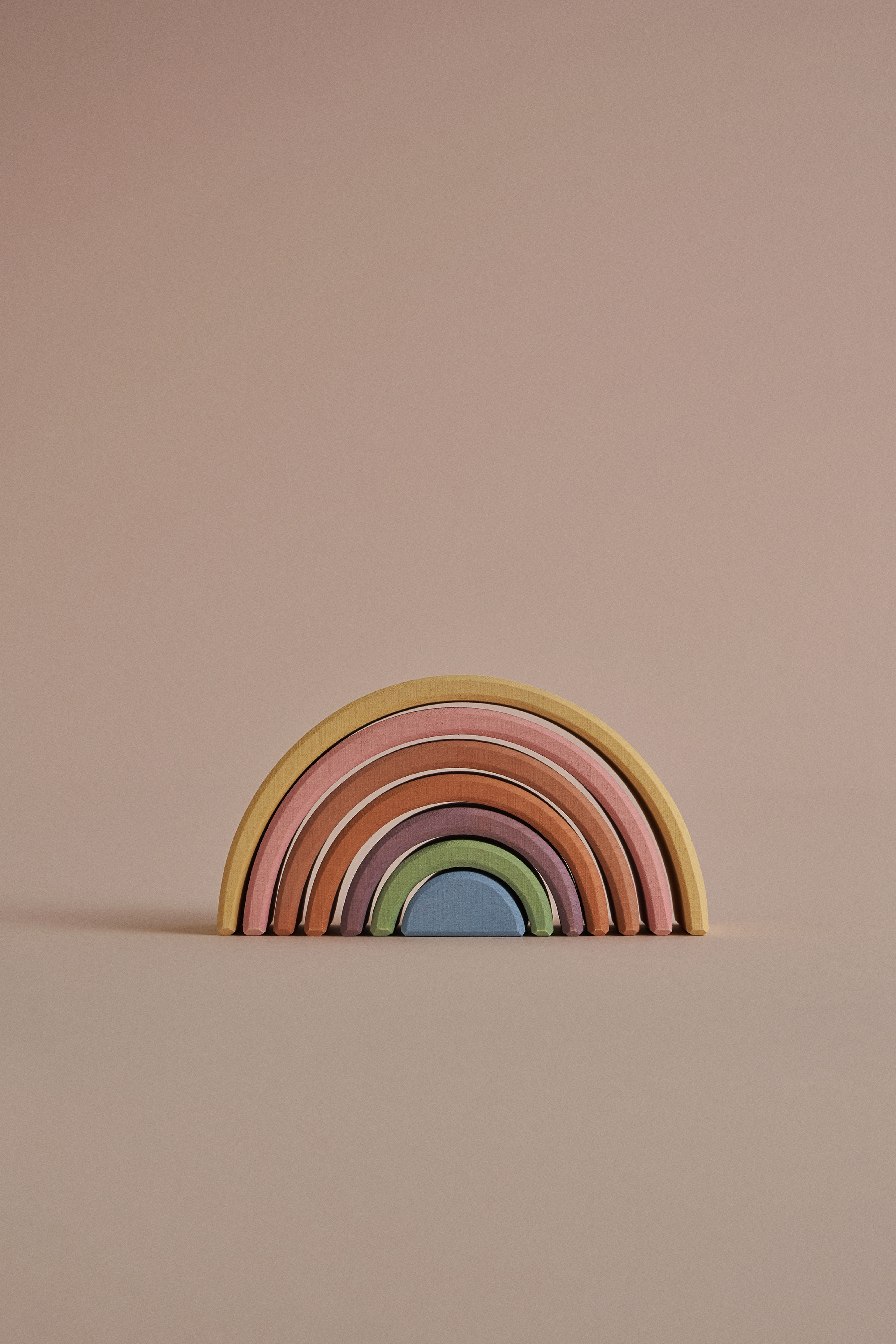 Houten speelregenboog van Raduga Grëz met gebogen bogen in zachte, natuurlijke kleuren, voor stapelen, bouwen en fantasierijk