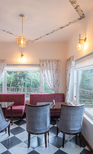 Corner House restaurant at Hotel Simla The Village featuring bay windows with a view of Shimla valley.