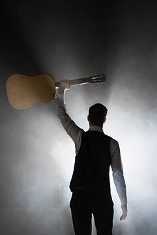 musician-stage-holding-his-classical-guitar.jpg