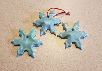 three snowflake cookie ornaments, only one has ribbon