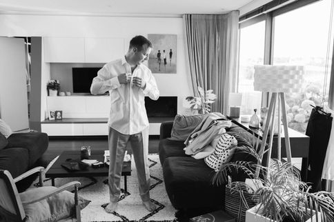 Le futur marié ajuste sa tenue dans un intérieur moderne, en pleine préparation de son grand jour – par Julien Stevens Photography