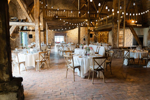 Salle de réception avec décoration rustique et guirlandes lumineuses – par Julien Stevens Photography