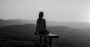 A girl looking out over a landscape to represent reflecting