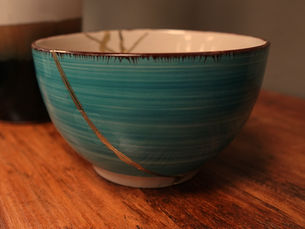 Türkisfarbene Schale mit goldener Kintsugi-Reparatur auf braunem Hintergrund – Symbol für den wertvollen Umgang mit Rückschlägen, Resilienz und mentale Stärke im Sport.