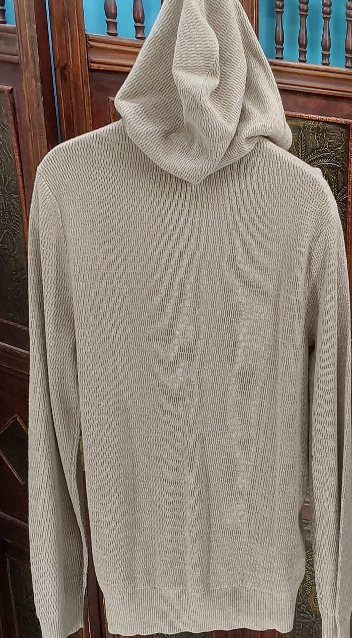 Thumbnail: A beige hooded sweater displayed from the back, featuring a textured knit pattern. The sweater has long sleeves and a relaxed