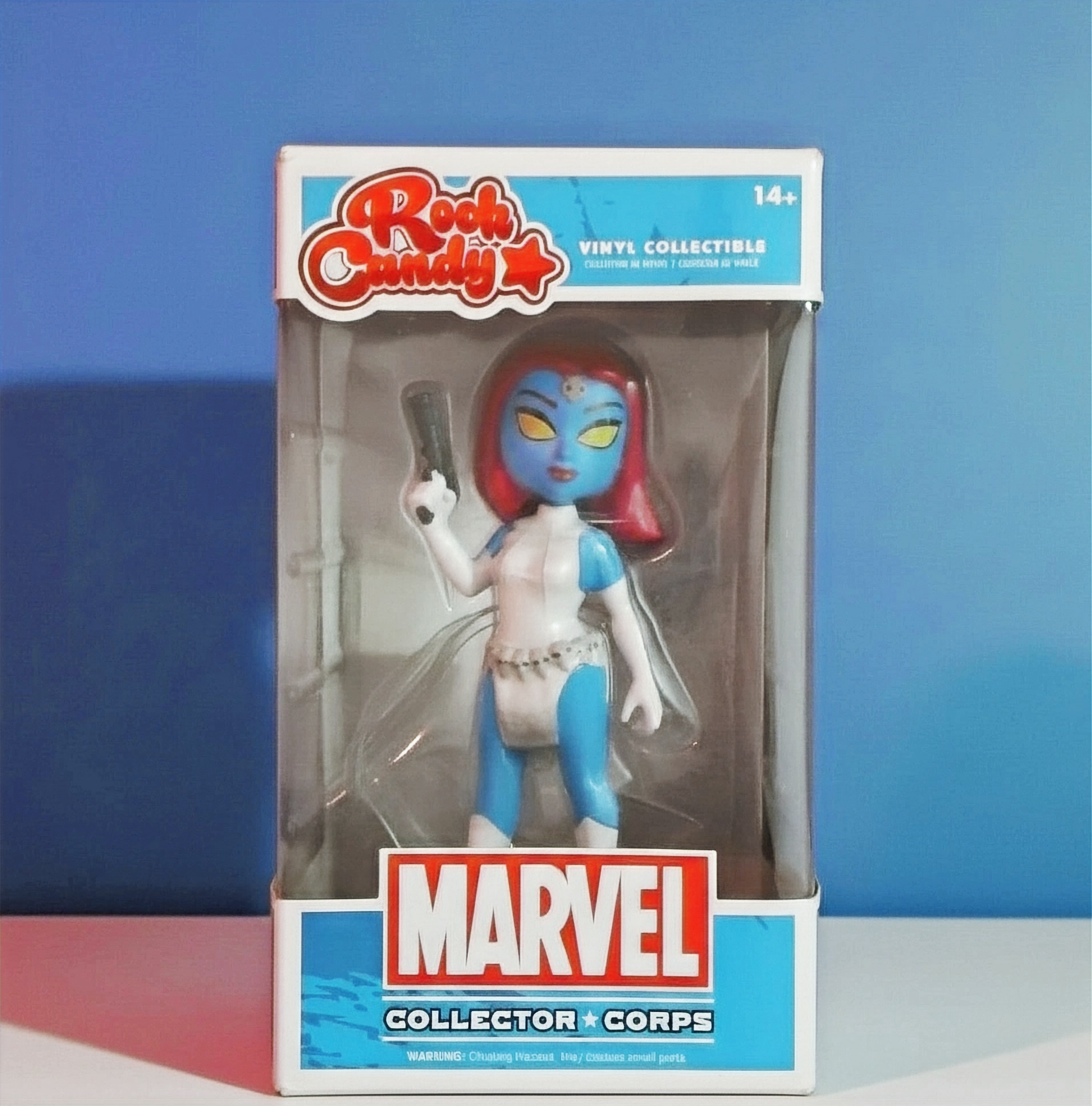 This image displays a Mystique vinyl collectible figurine, part of the Marvel Rock Candy series