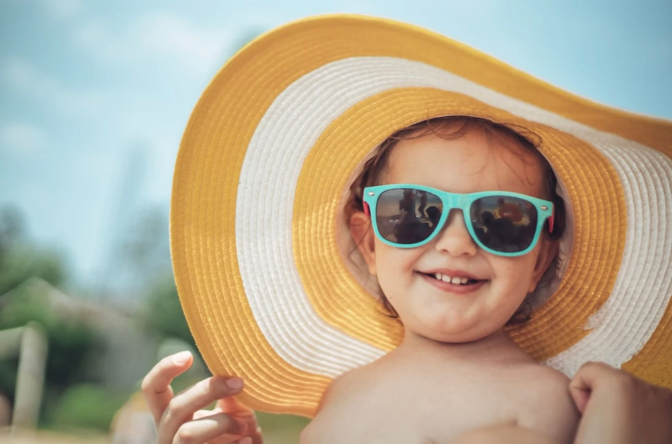 toddler protecting themselves from the sun with a wide-brimmed hat and sunglasses