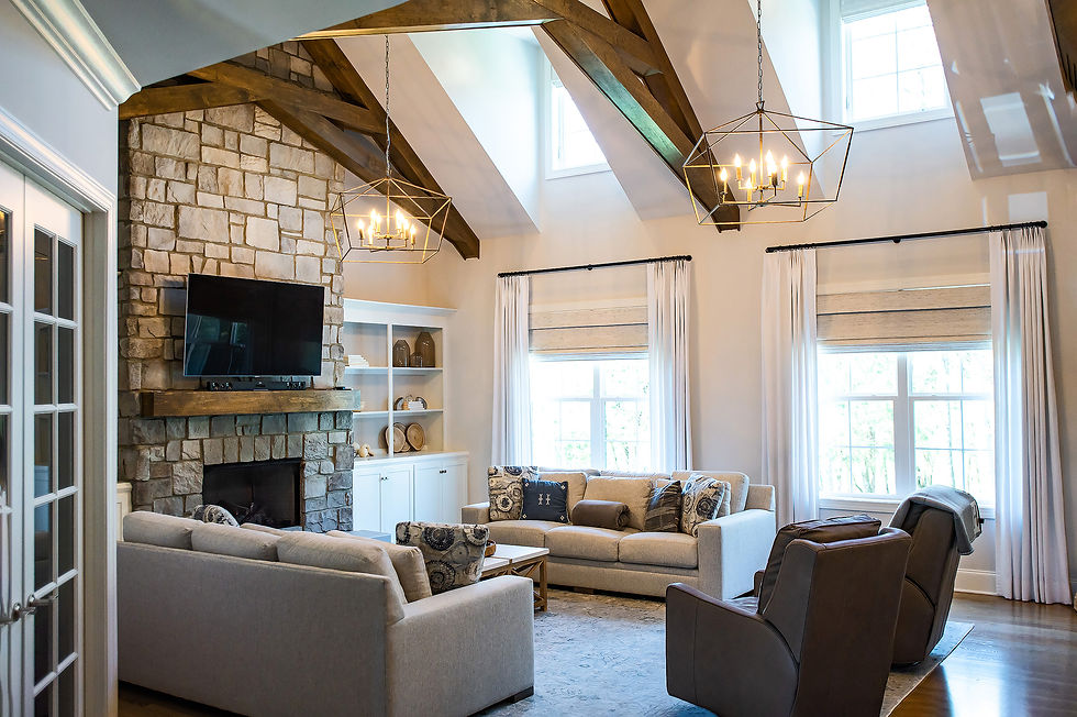 Great room with vaulted ceiling, exposed wood beams, stone fireplace, and neutral sectional seating — timeless interior design Gallatin Tennessee