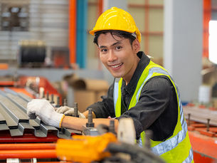 Worker in helmet and safety vest at factory.