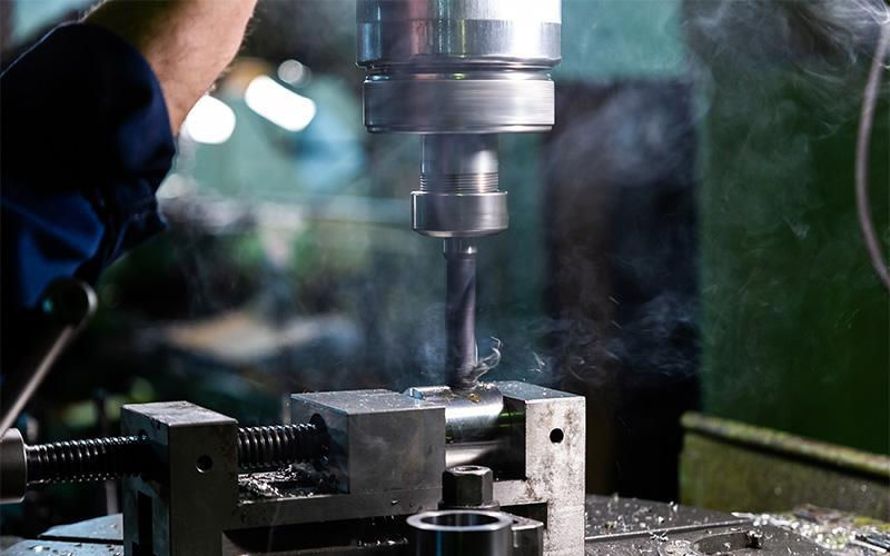 Precision CNC milling tool drilling into a clamped workpiece.