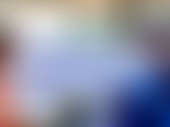 Two engineers wearing white hard hats and safety glasses discussing a technical blueprint