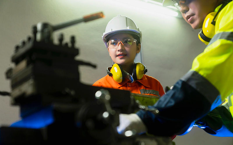 Technicians operating high-precision machinery in a disciplined manufacturing environment.