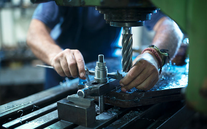 Close-up of high-precision machining with manual quality checks to ensure manufacturing reliability.