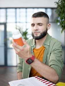 bearded-man-holding-pack-with-pills-while-sitting-2023-11-27-05-04-34-utc.jpg