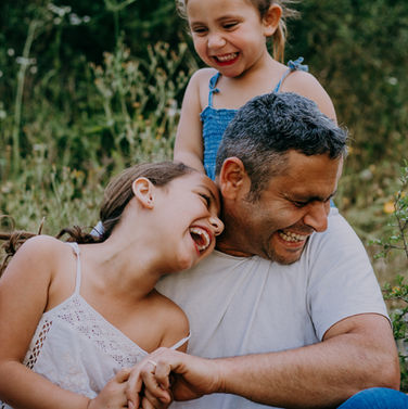 father and daughters laughing