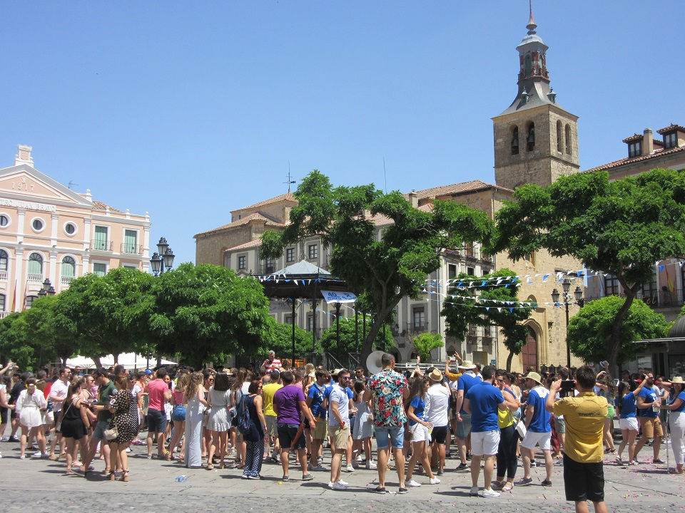 segovia plaza mayor városi ünnepség, amin nagyon sok ember vesz részt. háttérben egy templomtorony és a színház