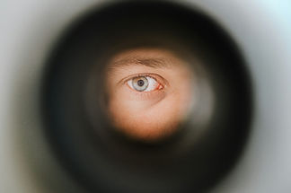 Eye looking through a peep hole spying