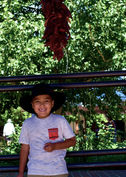 young boy standing by chile ristra