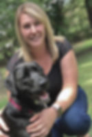A Labrador mix and Jaimie sit in the grass looking at the camera.