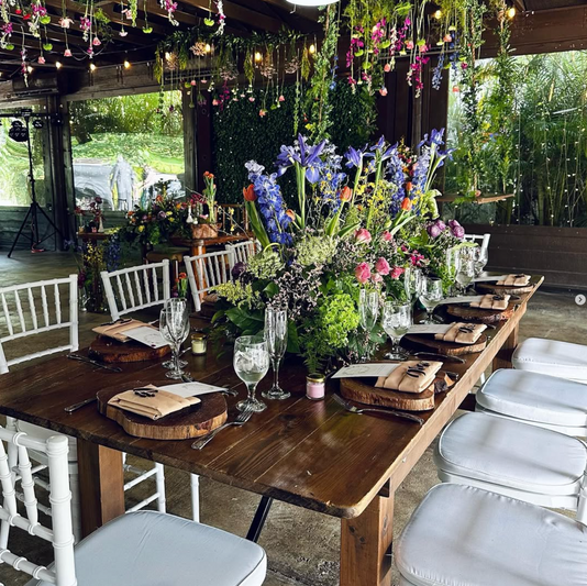 Outdoor wedding reception table with floral décor and catering by Chris Valdes Catering