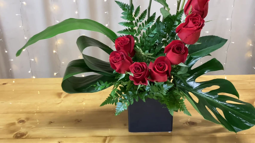 Thumbnail: A dozen red roses arranged in a curve.
