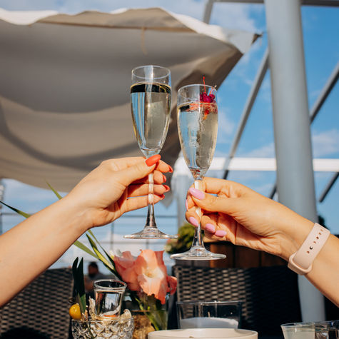 two-women-friends-eating-fresh-oysters-drinking-chilled-prosecco-wine-summer-sunset-restau