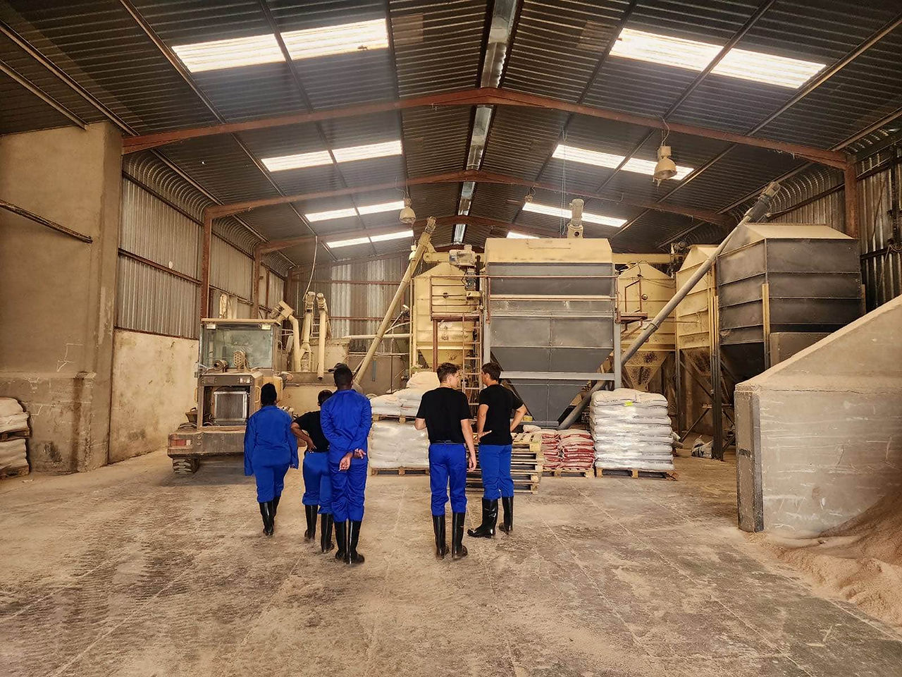 Graduate internship students standing inside feed mill