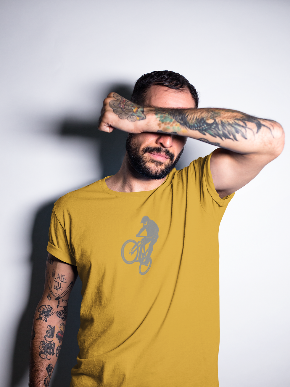 man wearing a yellow t shirt with a silhouette design of a mountain biker on the front