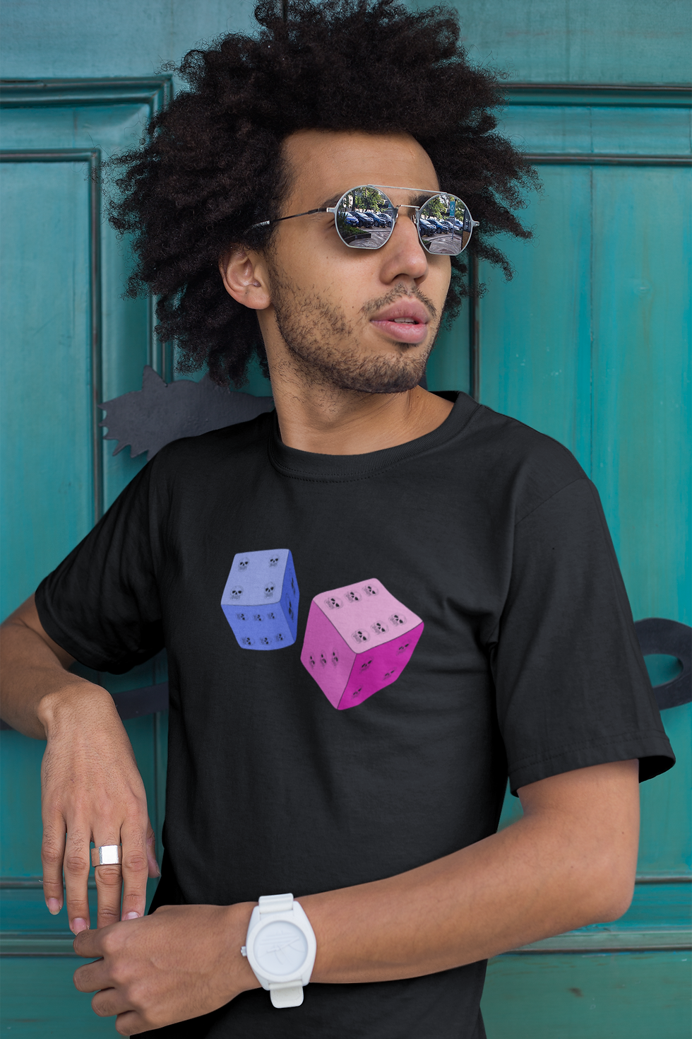 Black man wearing shades and a black T shirt with pink and blue dice featuring skull dots