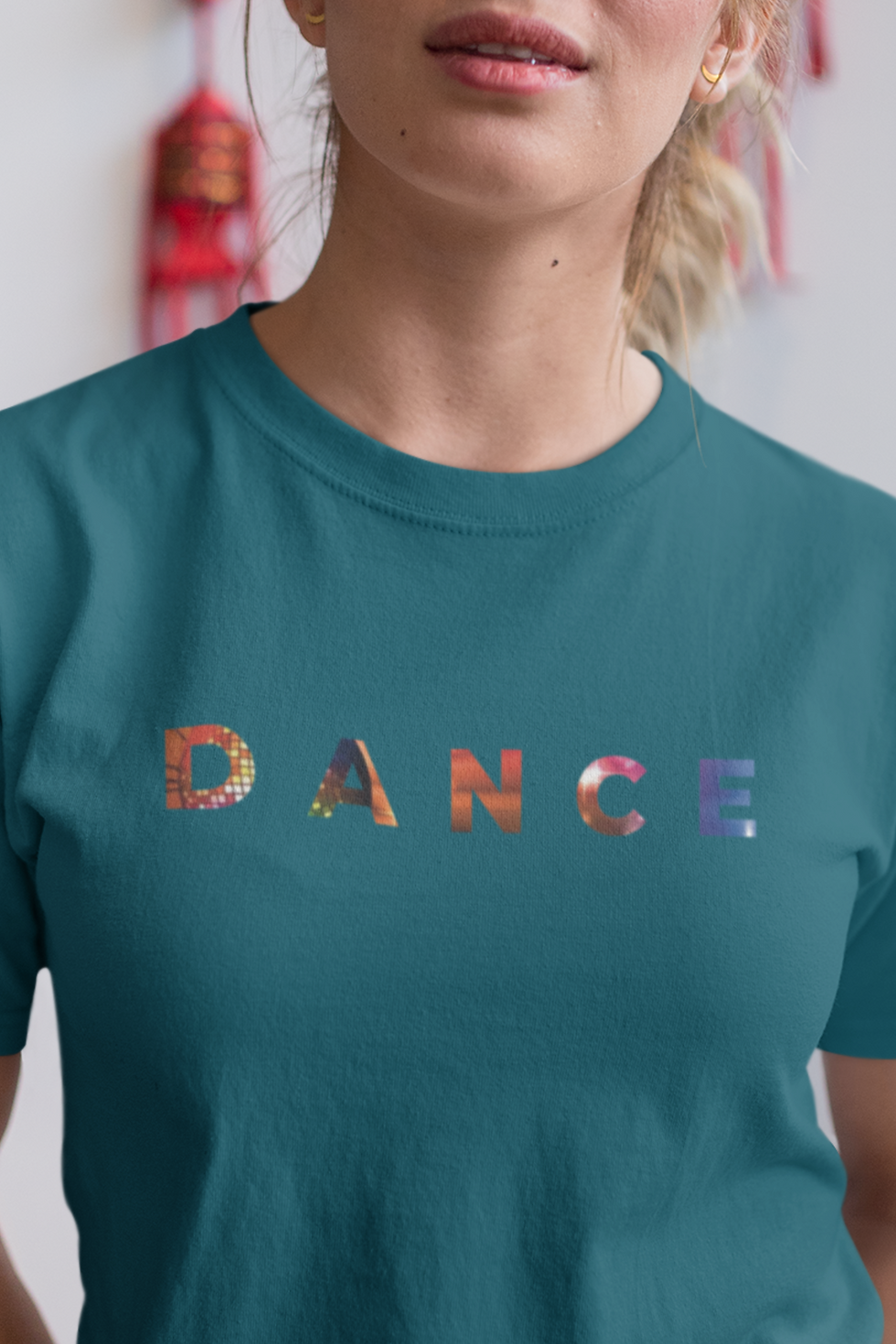 woman wearing a green t shirt with the word Dance on the front in bright colours