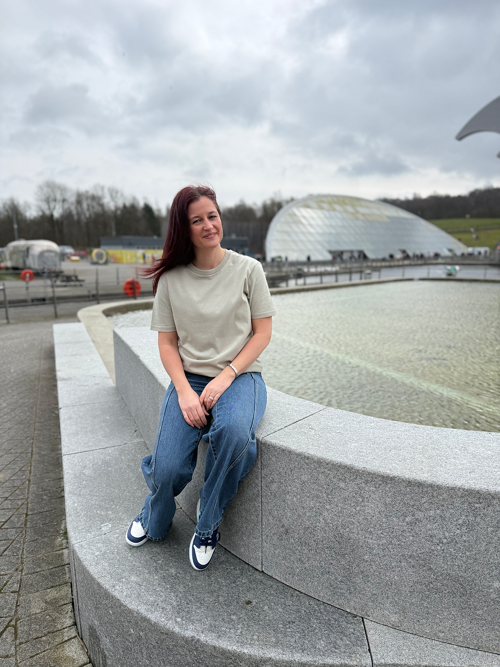 Thumbnail: Woman sitting on a wall wearing a Black Squirrel Clothing T Shirt