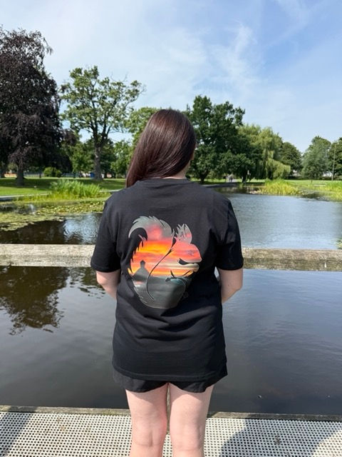 Thumbnail: Woman with a Sunset Photo on the back of a black T Shirt