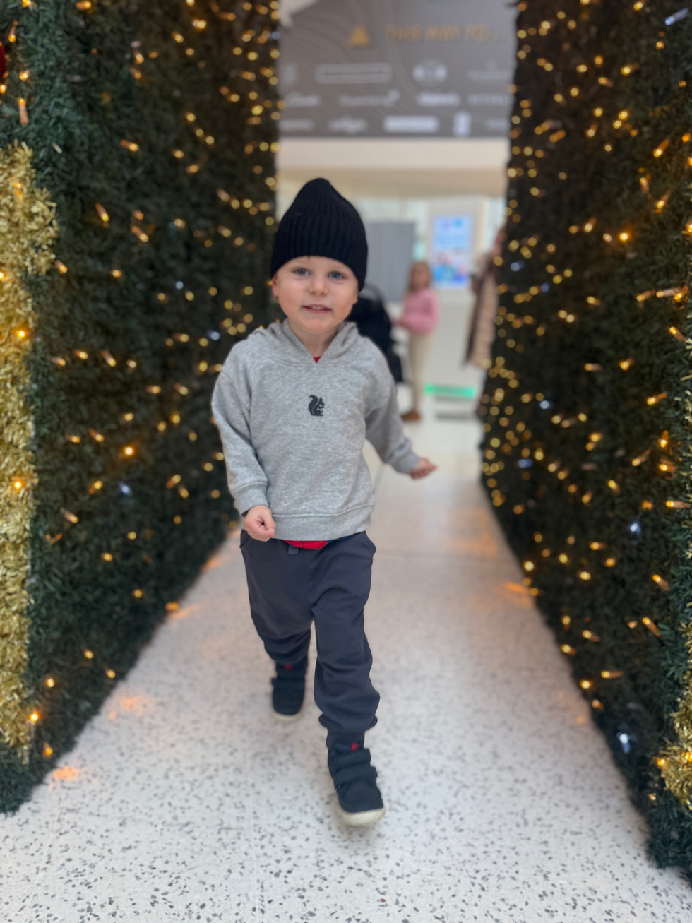 Toddler running wearing a black hat and grey Black Squirrel Clothing Hoodie
