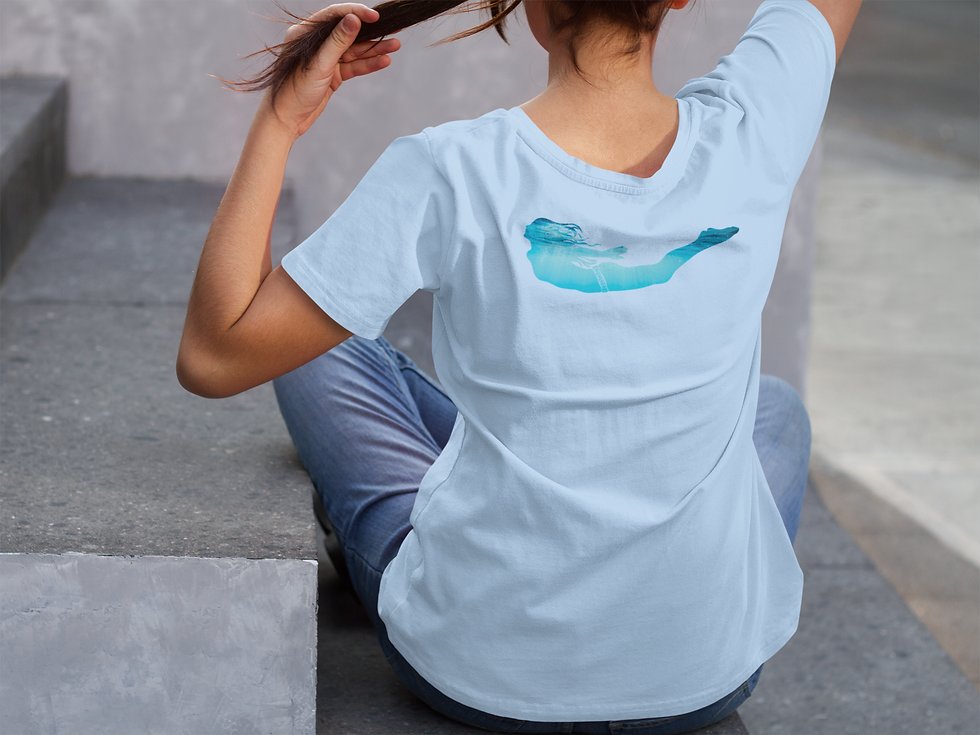 Rear view of a woman sitting holding her ponytail wearing a blue t shirt with a silhouette of a woman swimming on the back