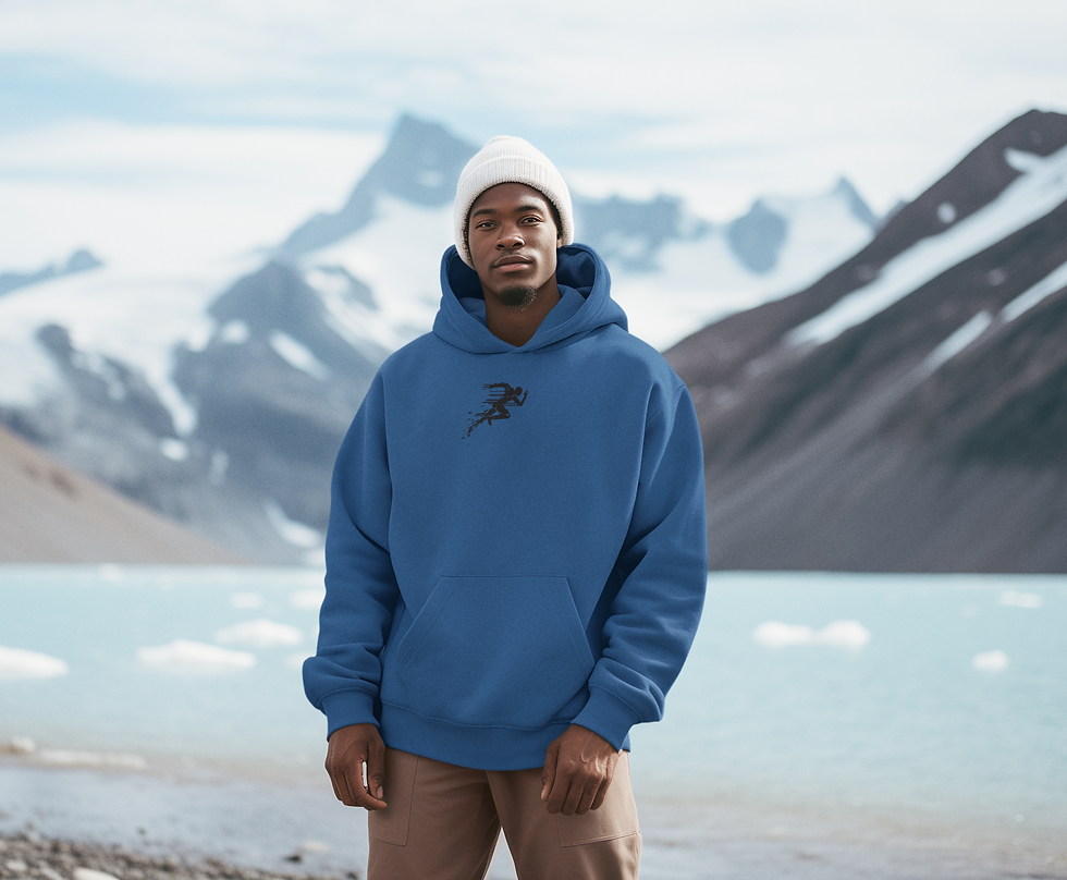 Man standing in front of a lake and mountains wearing a white hat and a blue hoodie with  black design of a runner