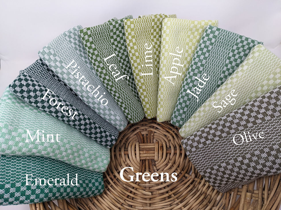 Basket of handwoven cotton hanging kitchen towels in shades of green