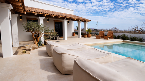 Exterior view of Tres Villa in Todos Santos, Mexico, featuring modern architecture, open-air living spaces, desert landscaping, and a central gathering area surrounded by the Baja landscape.