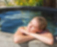 Woman soaking in a hot spring mineral water tub at a spa on Miracle Hill