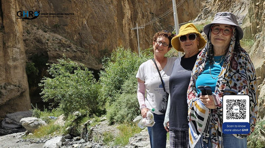 Three women posing for a photo. GHR logo and QR code. Great Himalayan Routes.