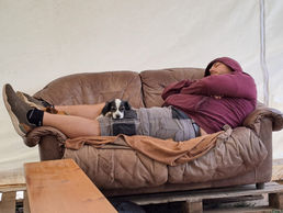 Hundeschulinhaber döst mit Hund auf dem Schoß