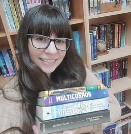Chica con el pelo castaño largo, sujetando cuatro libros
