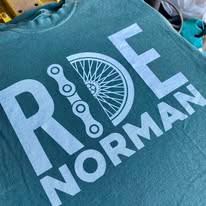 Green t-shirt that says "RIDE Norman"